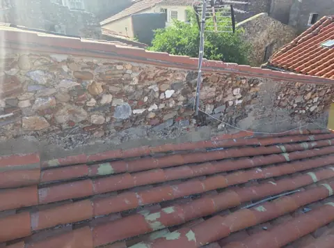 Avant : toit contre mur en pierre, avant intervention